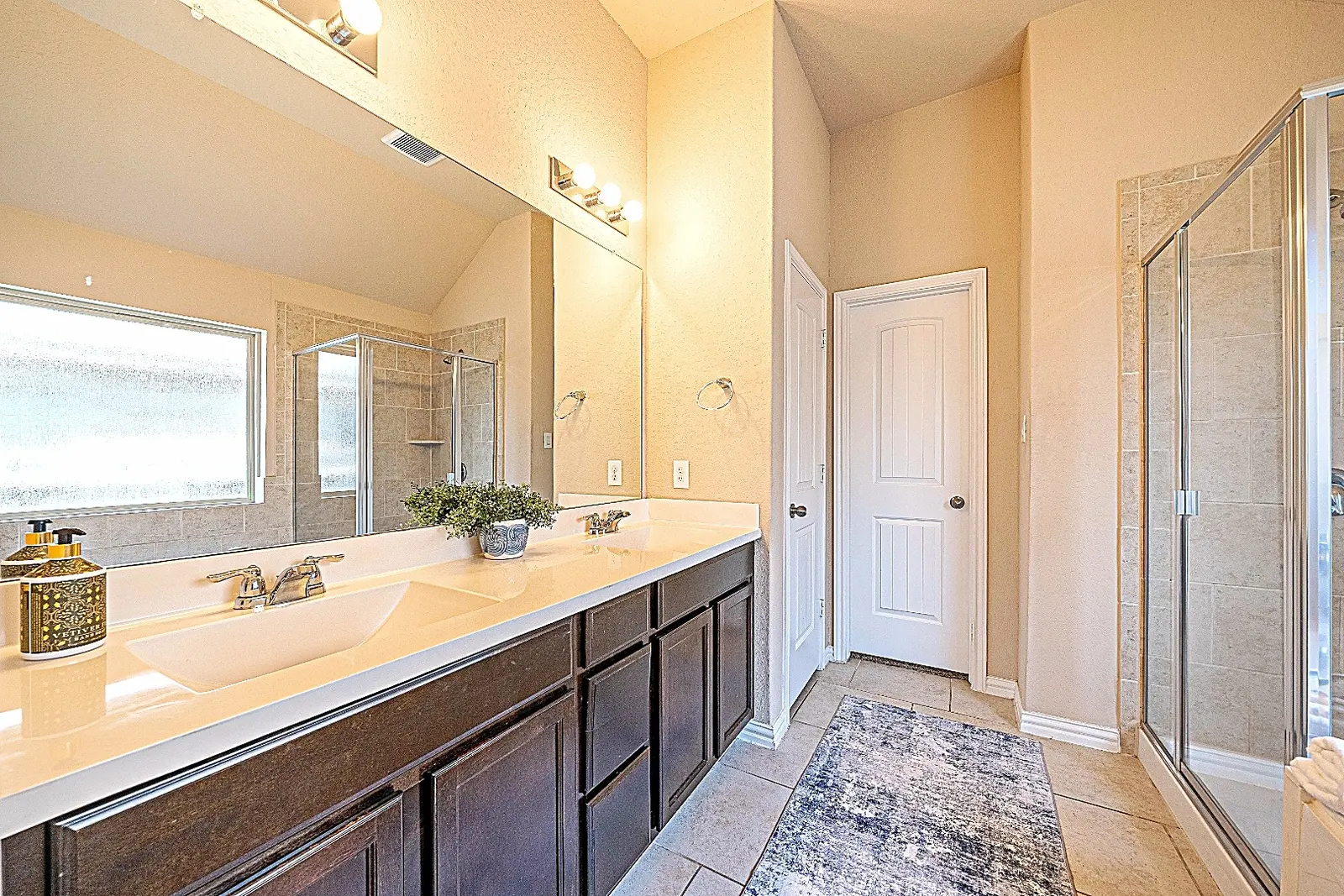 Primary bathroom with double vanity, soaking tub, and shower at Rawhide Way